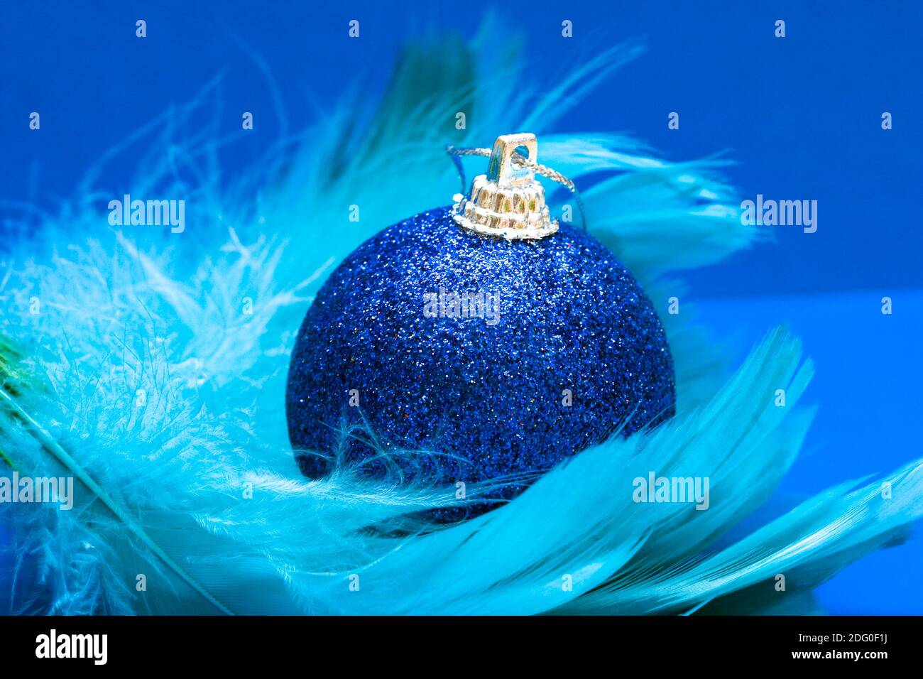 Palla di Natale su piuma blu Foto Stock