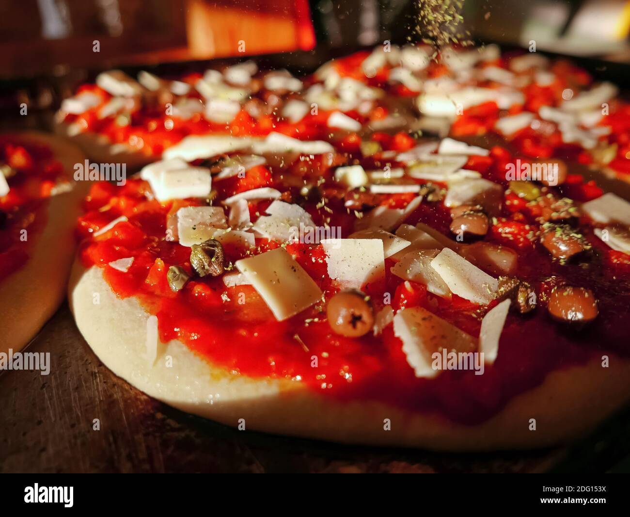 Pizza tradizionale italiana con mozzarella di pomodoro e olive, preparazione del prodotto Foto Stock