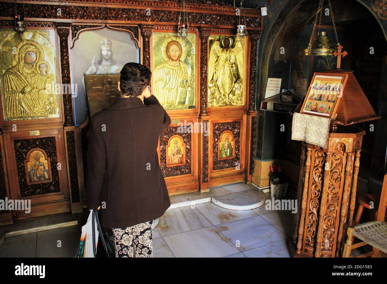 Pellegrini che pregano all'interno di una chiesa ortodossa greca ad Atene, Grecia - Marzo 12 2020. Foto Stock