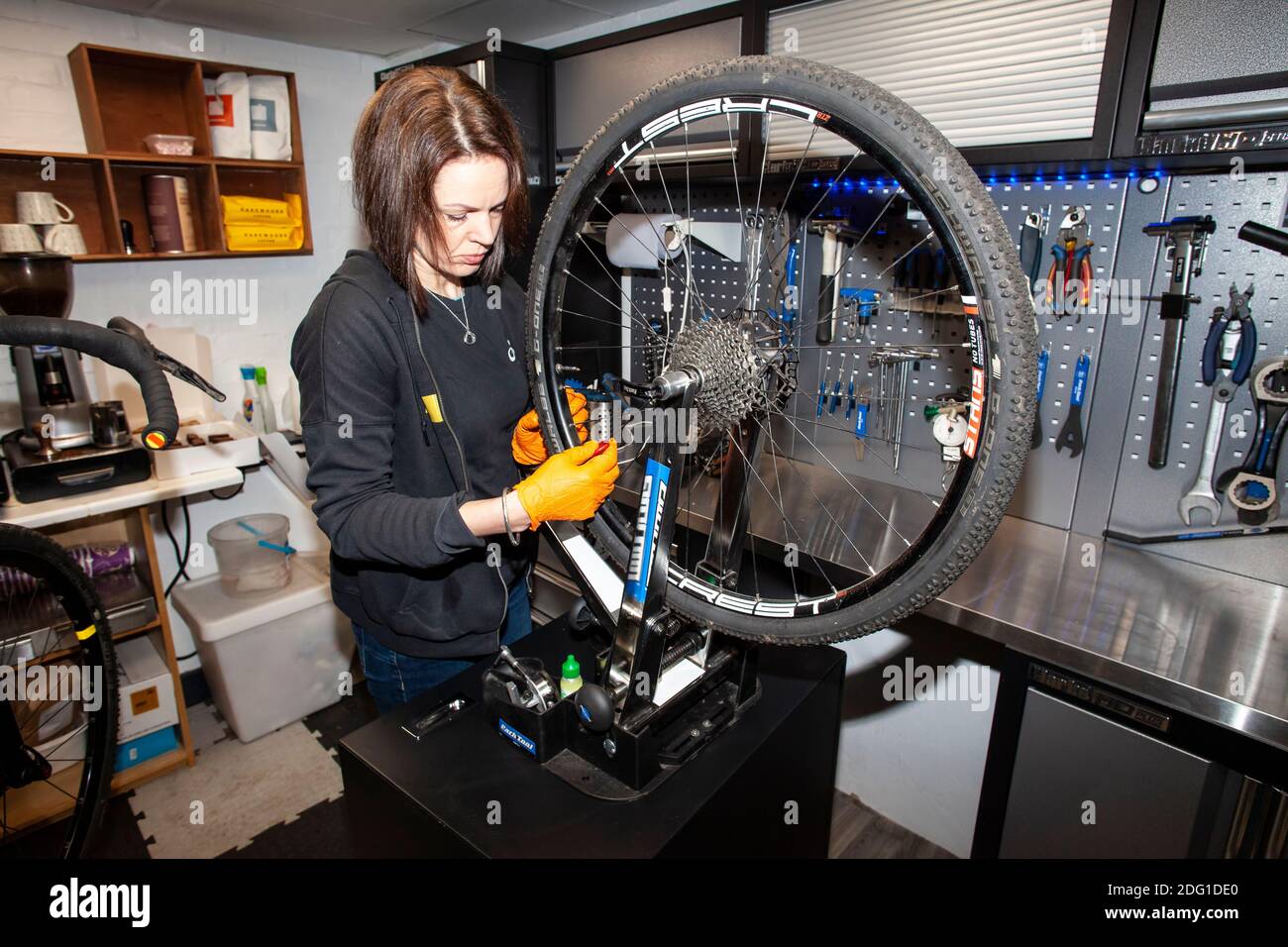 Un tecnico di bici Cytech completamente qualificato che controlla l'allineamento di una ruota posteriore della bicicletta in una riparazione professionale dedicata e. officina di manutenzione Foto Stock