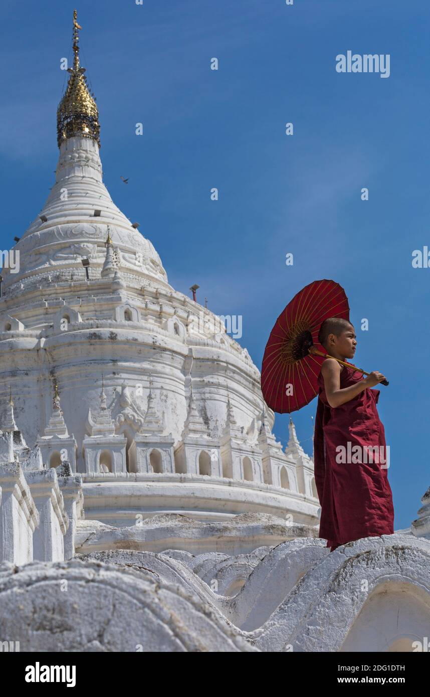 Giovane debuttante monaco buddista holding ombrellone a Pagoda Myatheindan (noto anche come Pagoda Hsinbyume), Mingun, Myanmar (Birmania), l'Asia in febbraio Foto Stock