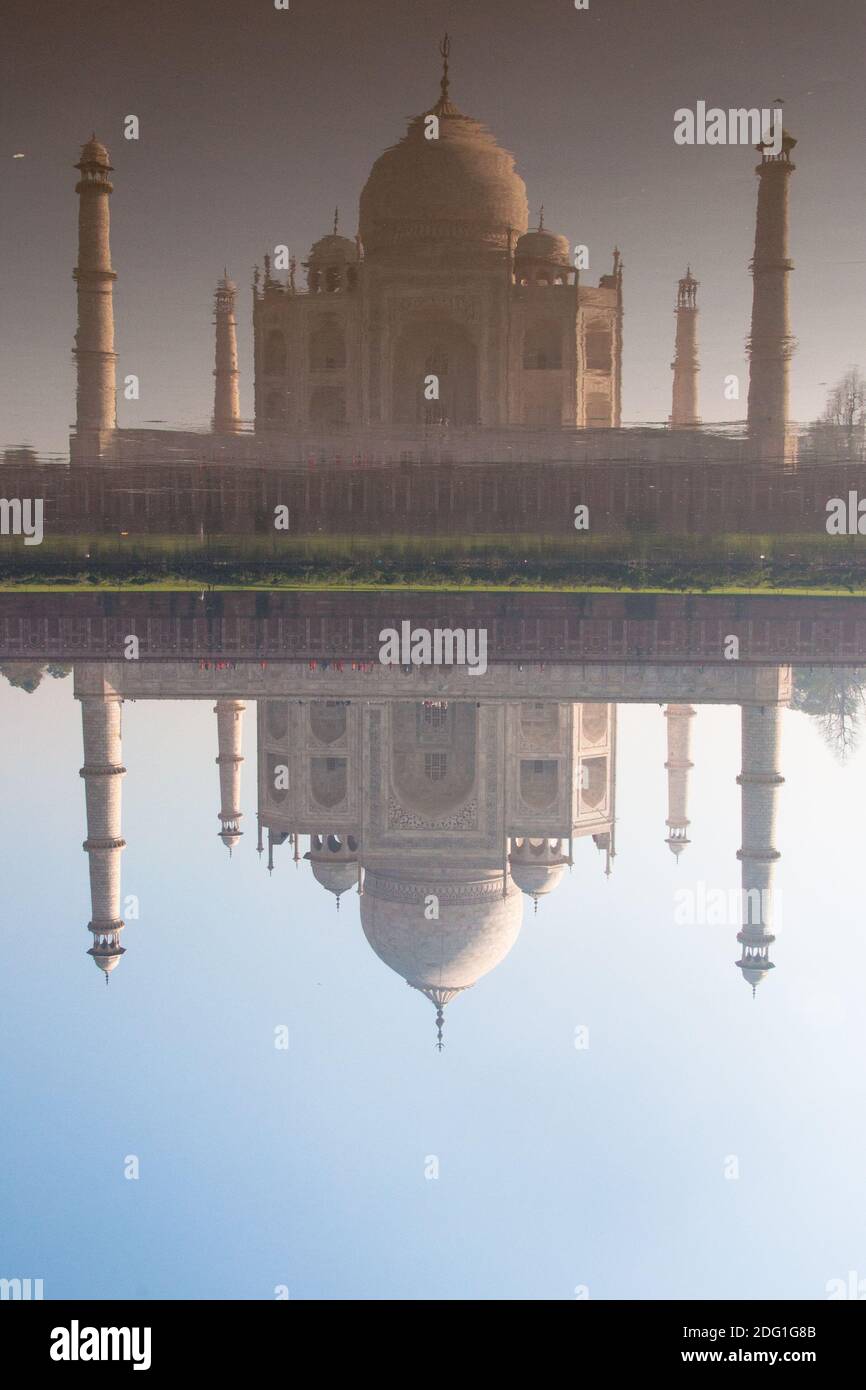 Vista frontale del riflesso in acqua del Taj Mahal in una mattina luminosa e soleggiata Foto Stock