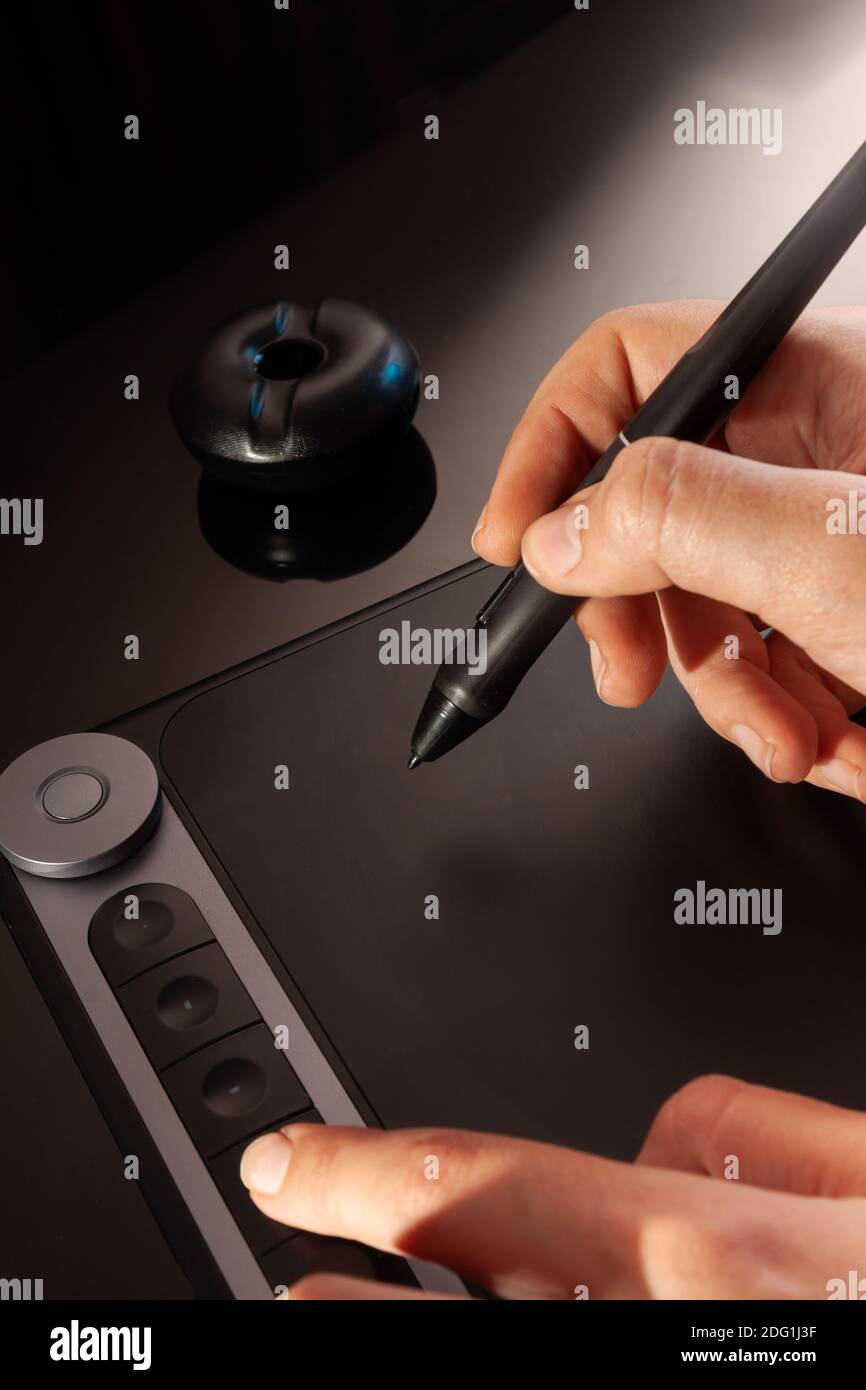 Designer grafico che lavora con la tavoletta grafica. Sfondo scuro Foto Stock