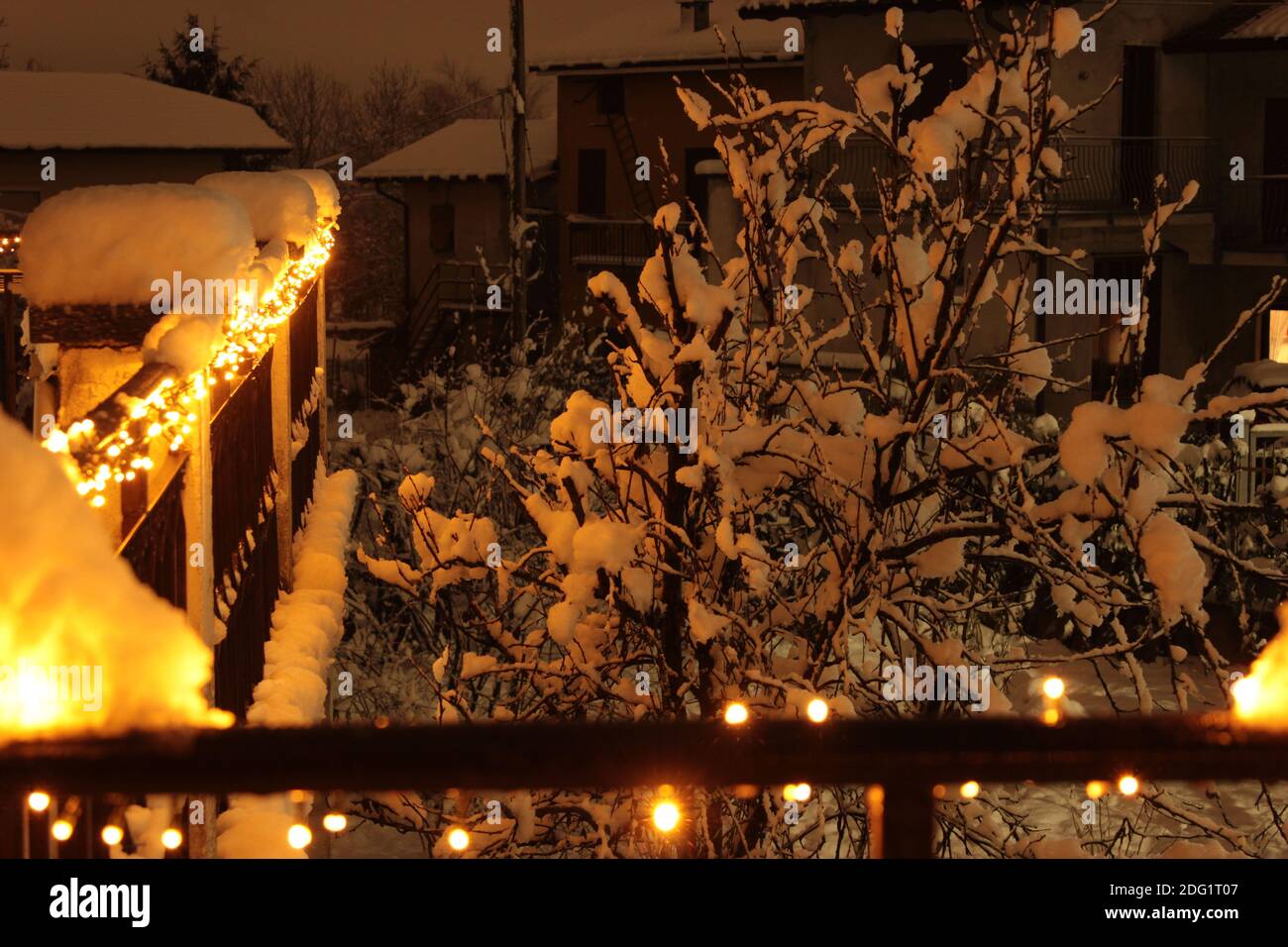 Luci di Natale allestite sul balcone di una capanna sparata in tutta la loro gloria durante una nevicata pesante. Sfondo romantico e adatto per le carte di Natale Foto Stock