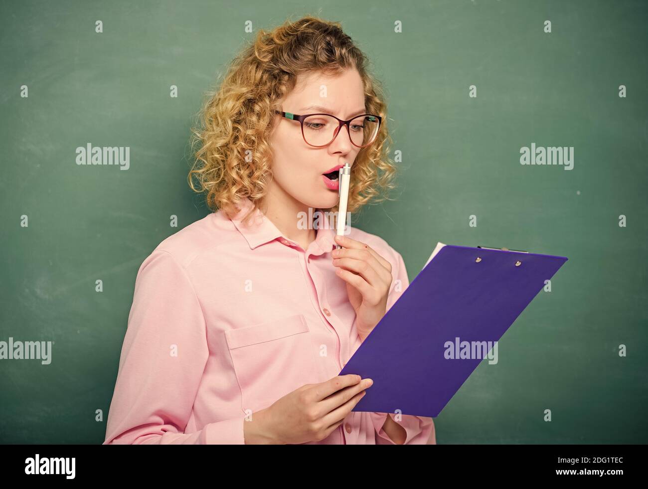 L'insegnante di letteratura ha letto la composizione. Leggere il ripristino con l'impressione. Progetto scolastico. Il tutor controlla le esercitazioni. Donna intelligente donna tenere documenti tablet. Leggi il profilo personale. Saggio di stima dei candidati. Foto Stock