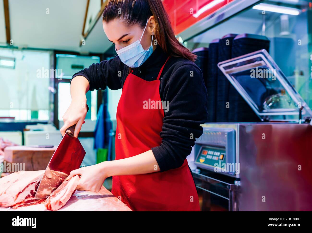 donna macellaio che taglia una buona bistecca di manzo Foto Stock