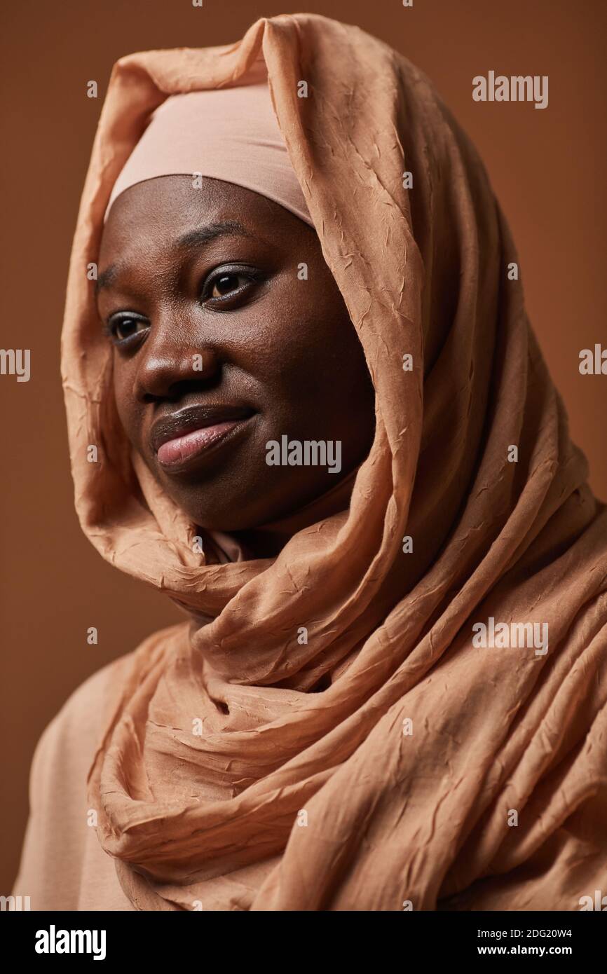 Ritratto verticale di una donna etnia afroamericana con foulard e sorridente con fuoco sugli occhi Foto Stock