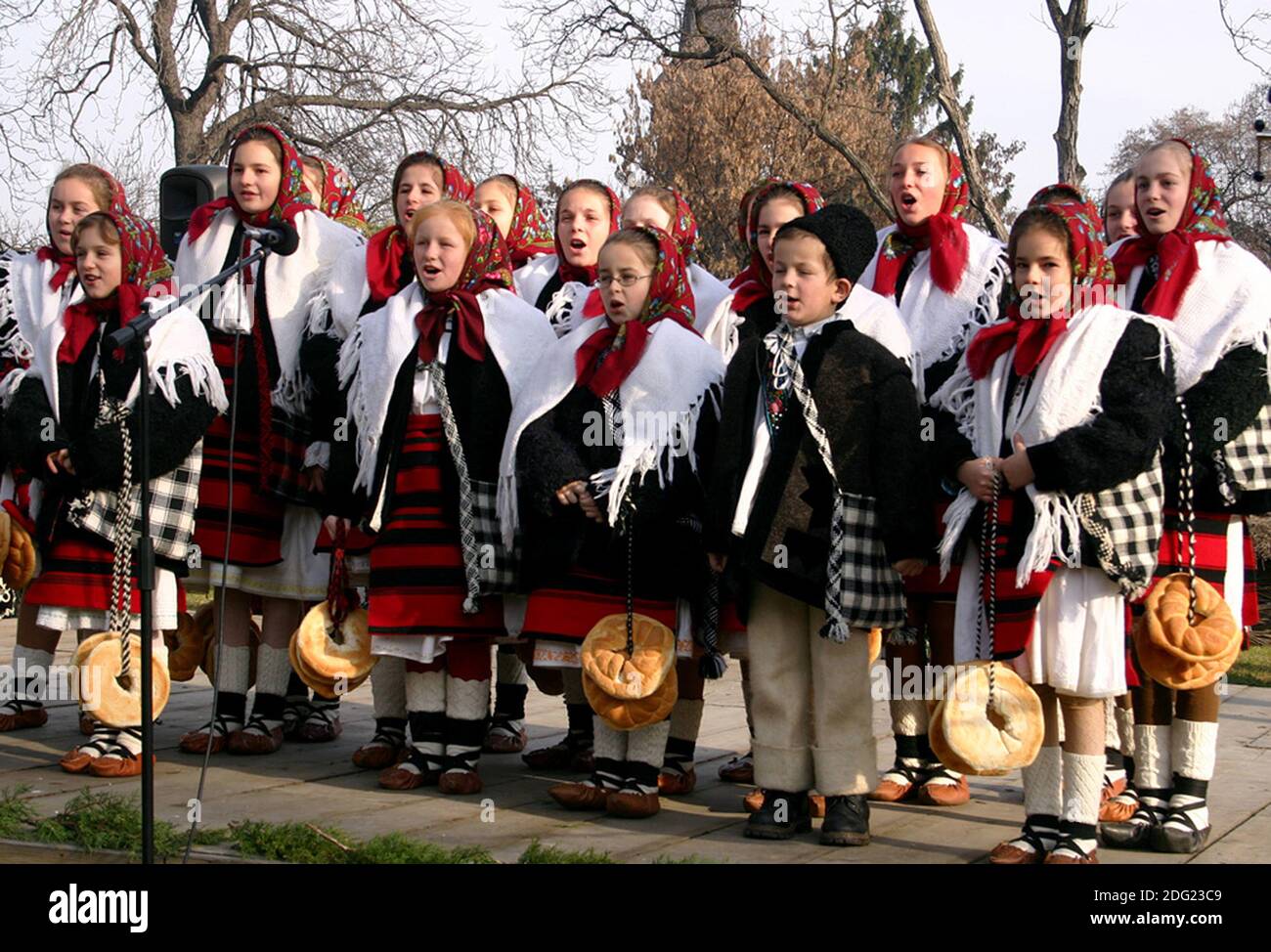 Gruppo di giovani carolieri rumeni in costumi tradizionali che cantano per Un evento di Natale Foto Stock