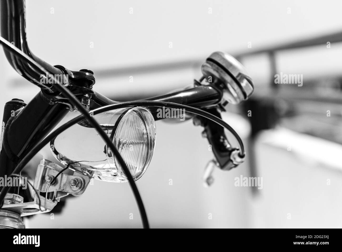 Un closeup scala di grigi di un manubrio di bicicletta con campana e. luce anteriore Foto Stock