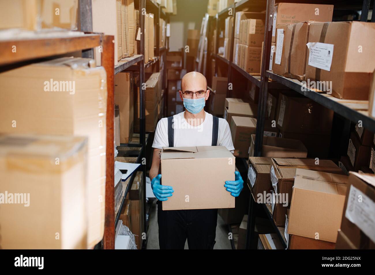 Scatola per il trasporto dei lavoratori in magazzino, con maschera e guanti. Foto Stock