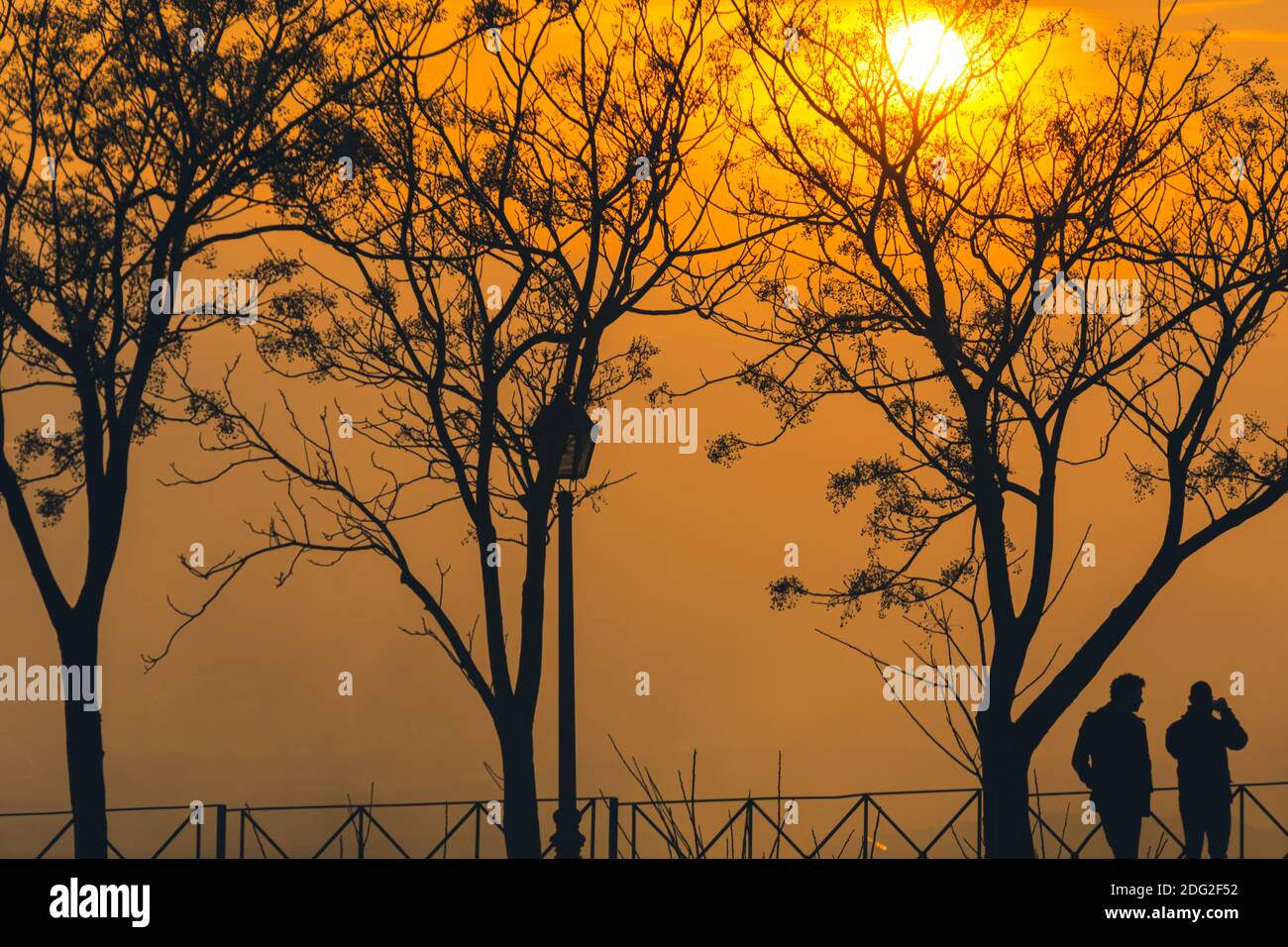 Sagome di persone che camminano lungo il Paseo de las Murallas De Baeza (Spagna) in un pomeriggio invernale con uno speciale leggero Foto Stock