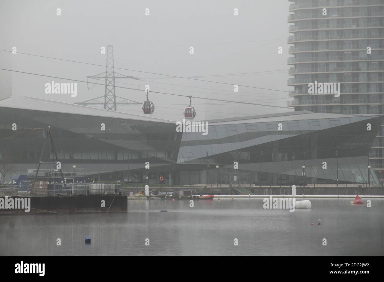 Le funivie Emirates scivolano oltre il Cristallo mentre scendono nella stazione Royal Docks.London è stata travolta da una fitta nebbia che ha ridotto la visibilità a meno di 200 metri e le temperature si sono ridotte al di sotto di 3 gradi centigradi. Foto Stock