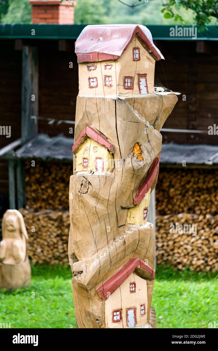 Copia stilizzata di piccole case su una montagna da un tronco di albero Foto Stock