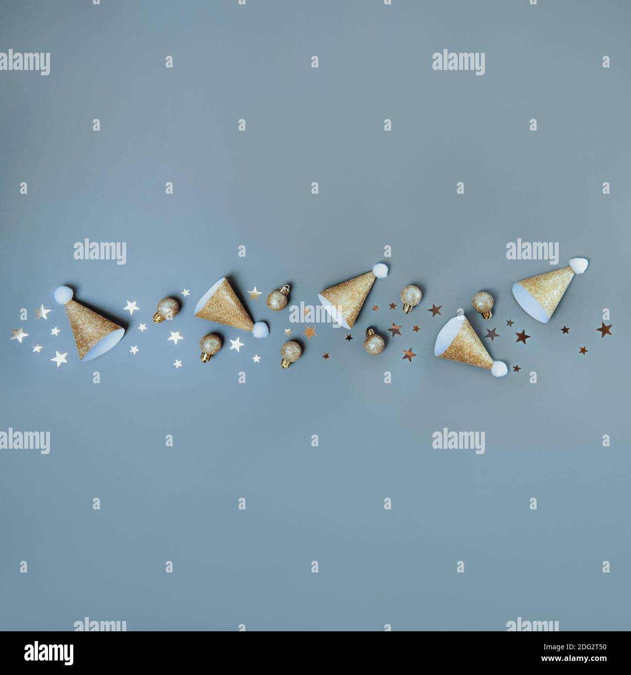 Sfondo di Natale creativo in blu muto. Foderato in carta festiva frizzante cappelli, palline e stelle. Concetto di layout per il nuovo anno. Atmosfera festosa Foto Stock