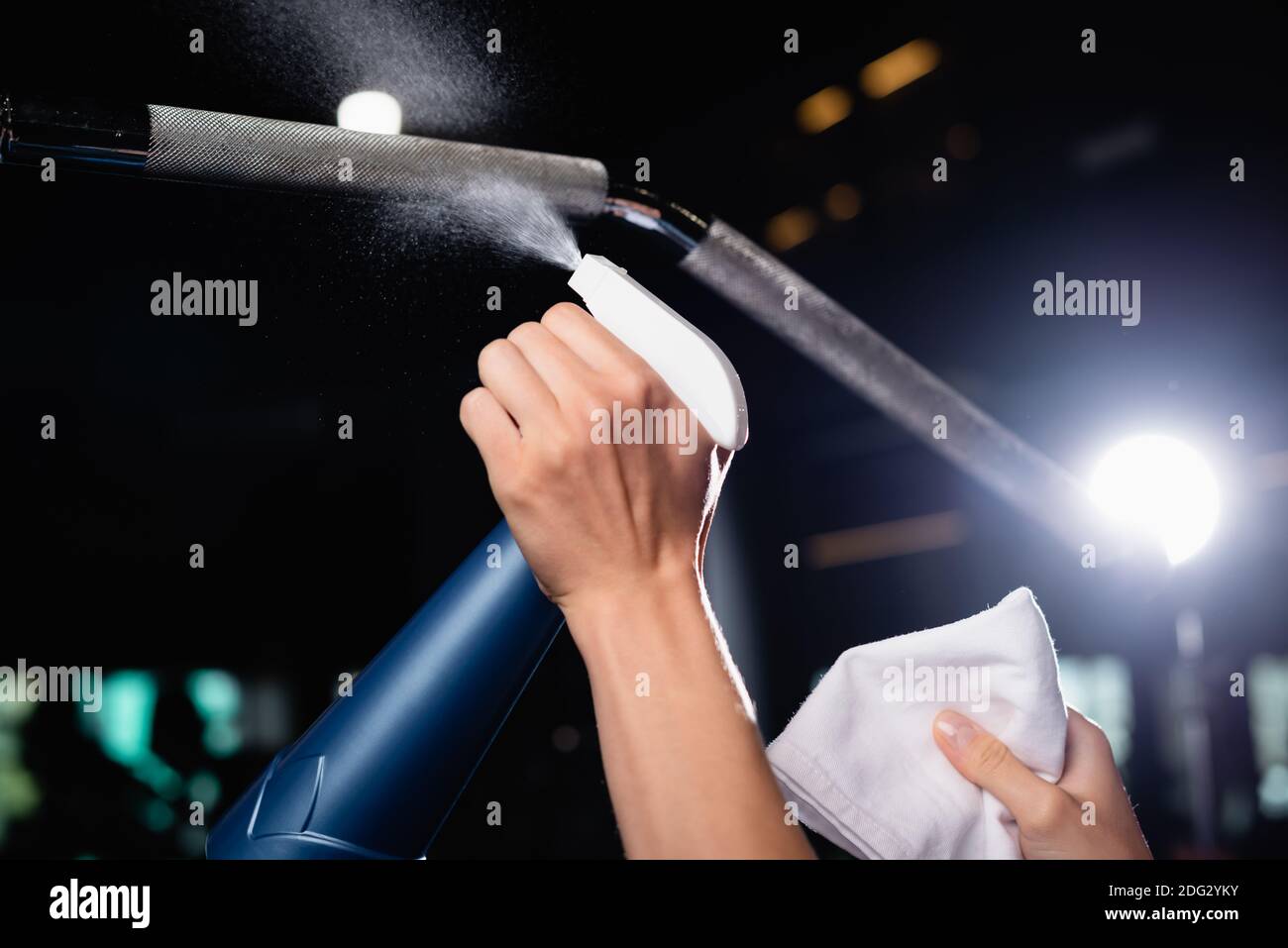 vista parziale del detergente spray per donna di mare sulle attrezzature sportive in palestra Foto Stock