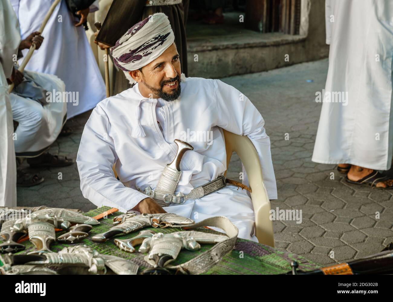 Nizwa, Oman, 2 dicembre 2016: Un fornitore sta vendendo khanjars - i pugnali tradizionali di Omani - al mercato della pistola di venerdì a Nizwa Foto Stock