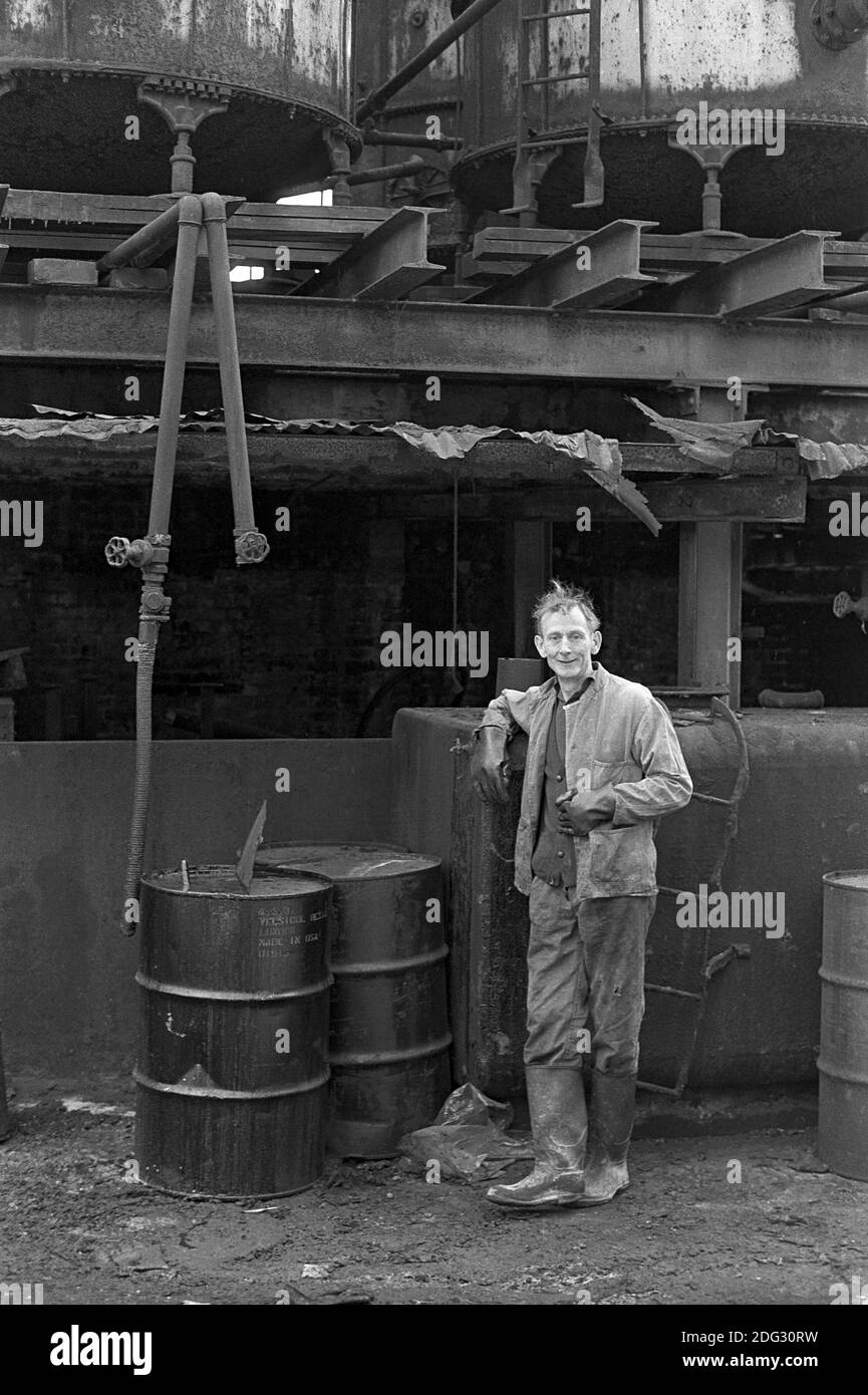 Regno Unito, Londra, Docklands, Isle of Dogs. Inizio 1974. Un uomo che lavora in un cantiere vicino a ColdhHarbour. Foto Stock