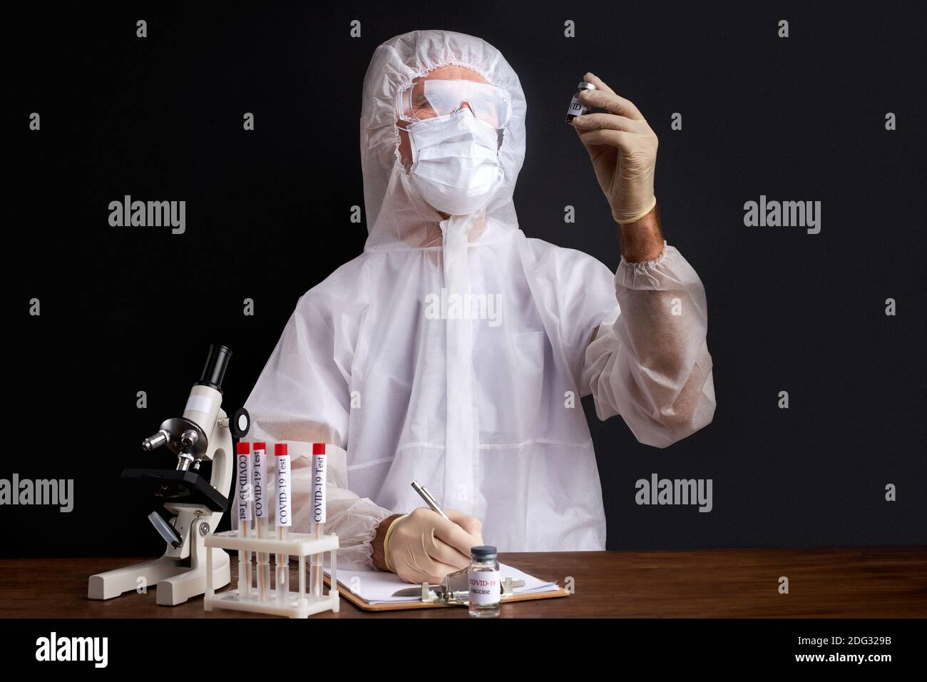 lo scienziato professionale sta facendo ricerca e sperimenta per trovare i farmaci per trattare il covid-19 in laboratorio, isolato su sfondo nero Foto Stock