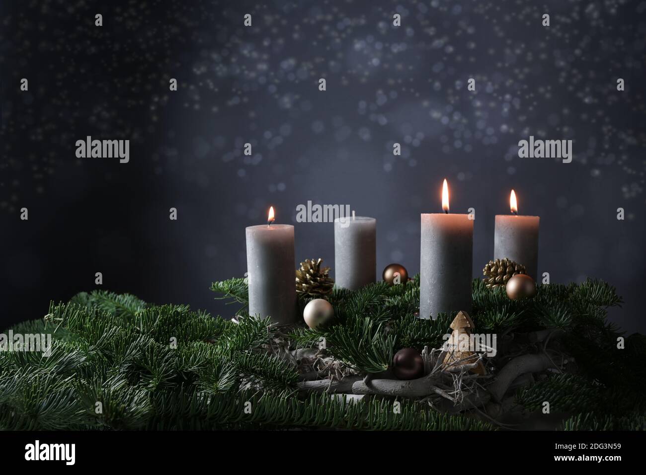 Terzo avvento con tre candele brucianti su rami di abete con decorazione di Natale contro uno sfondo grigio scuro, spazio di copia, fuoco selezionato, stretto d Foto Stock