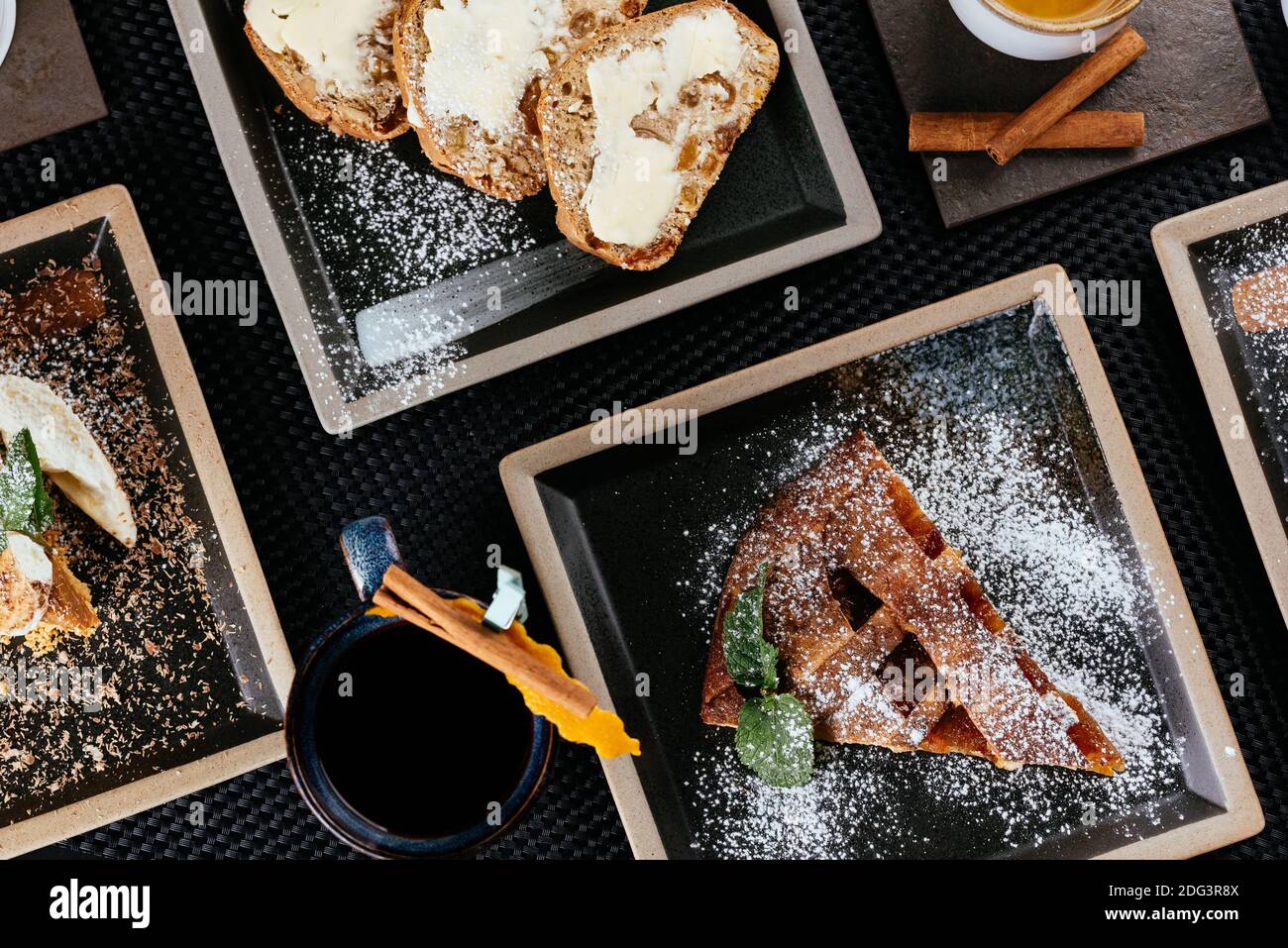 vari dessert con tè su sfondo nero Foto Stock