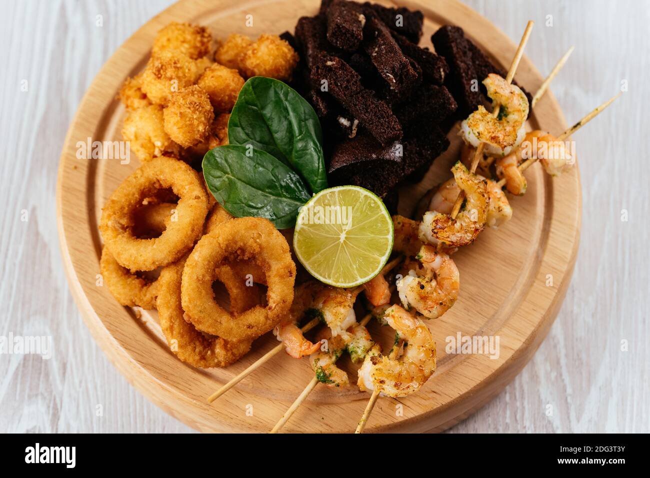 Spuntini di birra su una tavola di legno e sfondo chiaro Foto Stock