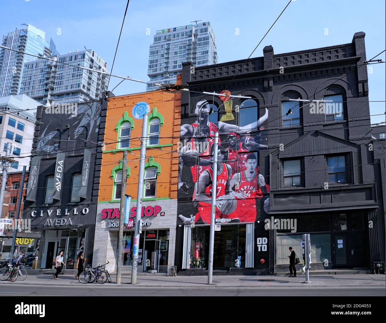 Toronto, Canada - 19 giugno 2019: Gli acquirenti passeggiano su Queen Street West di fronte ai negozi con facciate dipinte di colori. Foto Stock