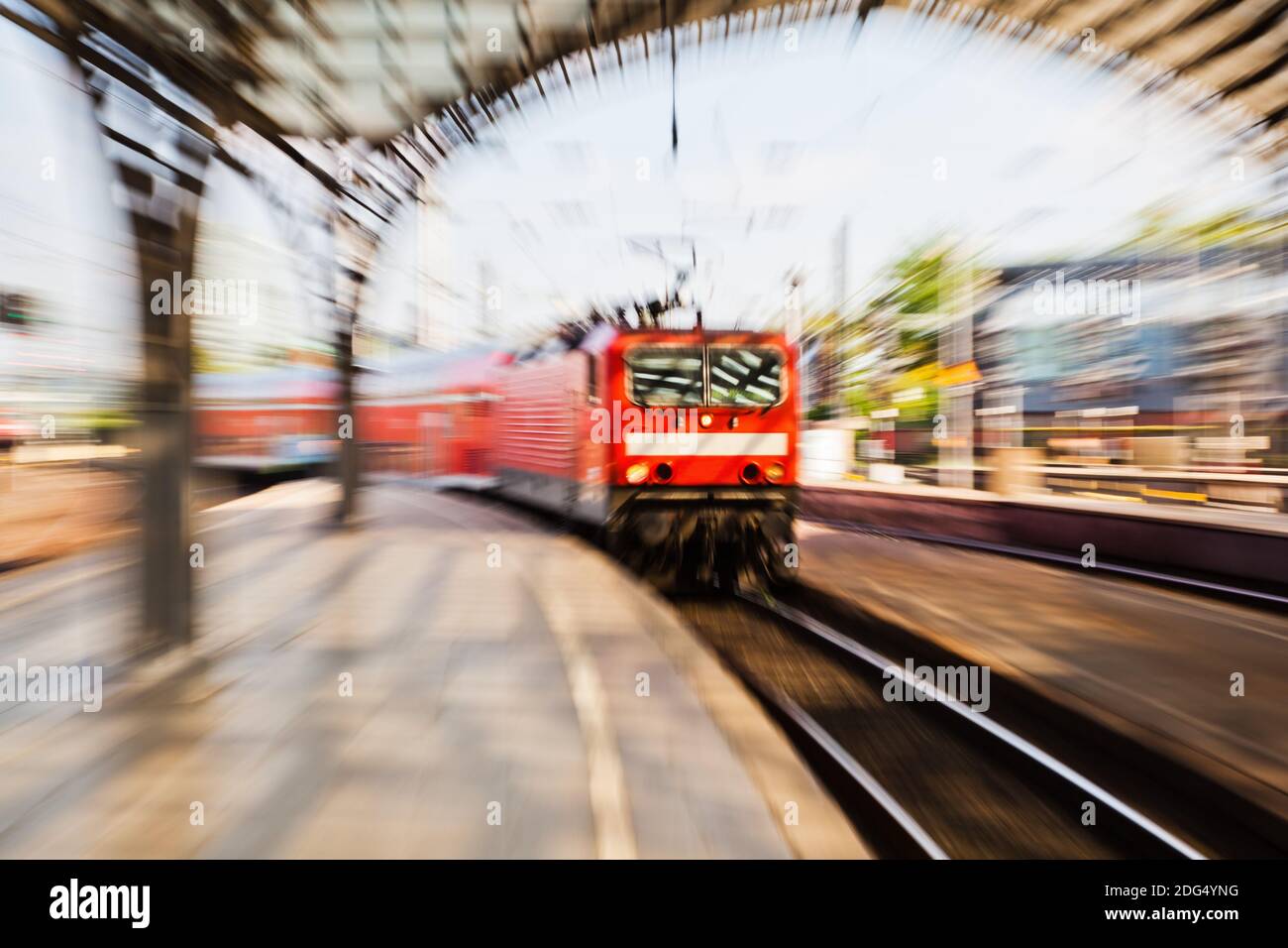 Arrivo in treno in una stazione ferroviaria con effetto zoom Foto Stock