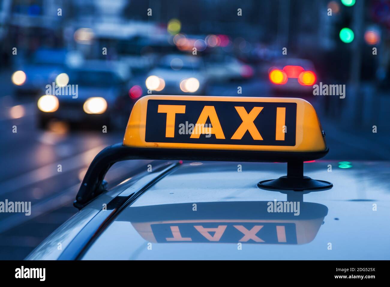 Cartello taxi illuminato sul tetto del taxi al crepuscolo Foto Stock