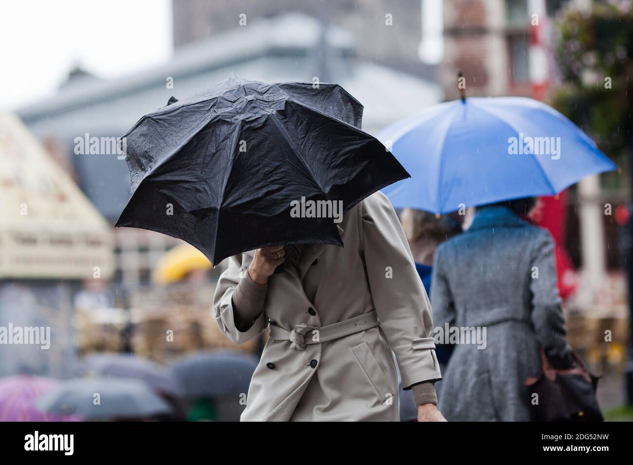 Persone con ombrello a pioggia nella città piovosa Foto Stock