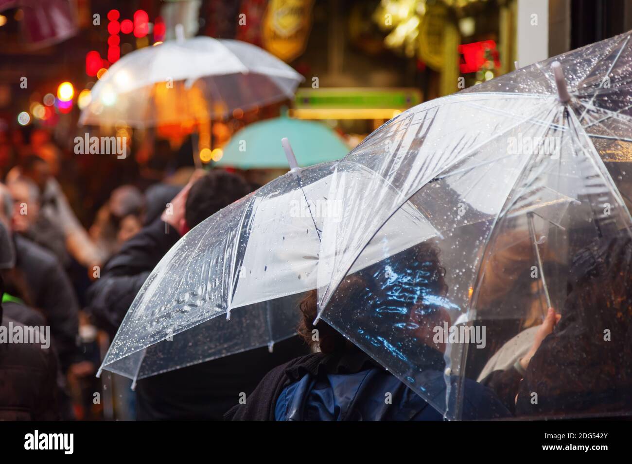 Donne con ombrelloni shopping nella città piovosa Foto Stock