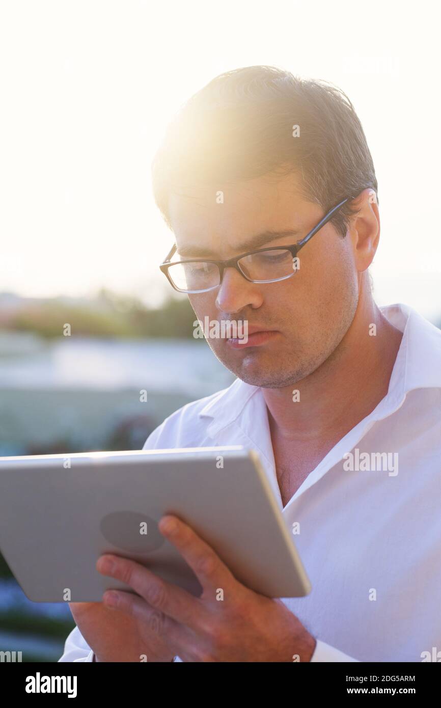 Giovane imprenditore profonda al lavoro con imbottitura outdoor Foto Stock