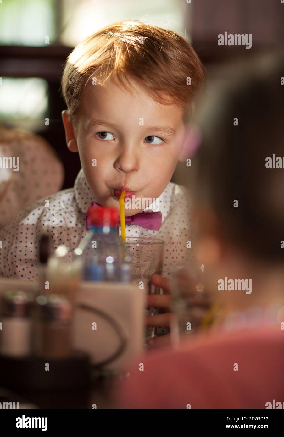 Piccolo ragazzo beve con un tubulo Foto Stock