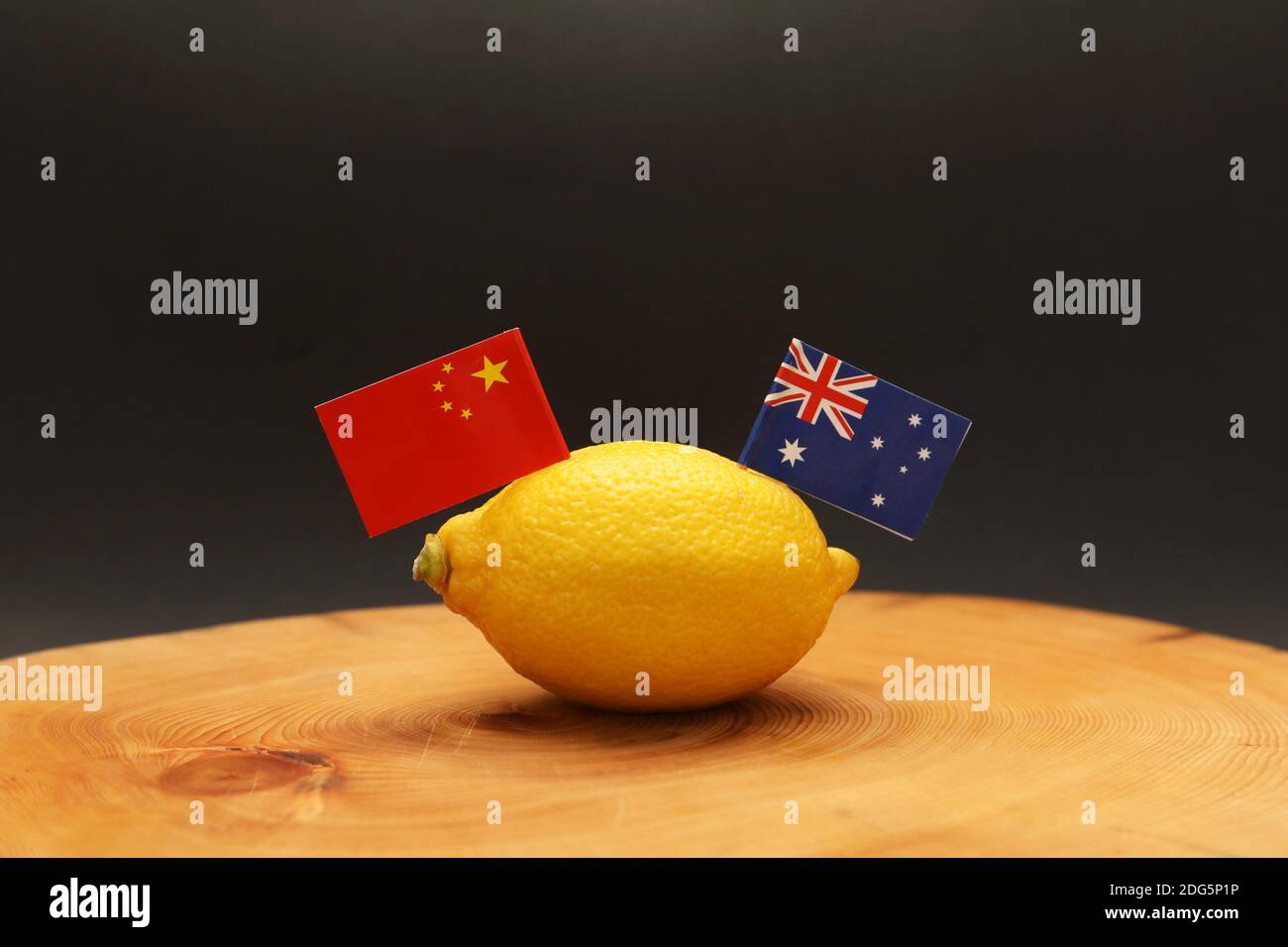 Bandiere australiane e cinesi che sventolano da un limone sopra un blocco di taglio che rappresenta il rapporto e il commercio soured sforzati la guerra è intercorso Foto Stock