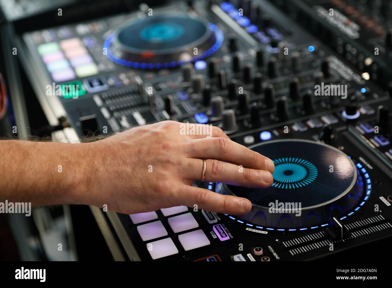 DJ che riproduce musica con il controller del mixer audio. Messa a fuoco selettiva. Foto Stock