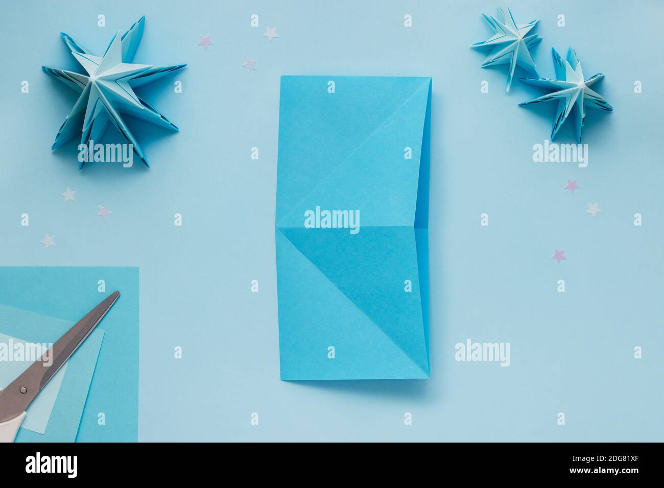 Semplice albero di Natale 3D origami fatto di carta blu. Istruzioni passo passo, passo 5. Distendere il foglio ruotandolo di 90 gradi e piegarlo nuovamente Foto Stock