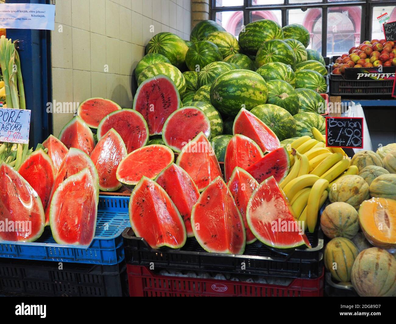 Cocomeri a fette avvolti in lamina, melone di miele e banana in un famoso mercato alimentare a Budapest, Ungheria in estate Foto Stock