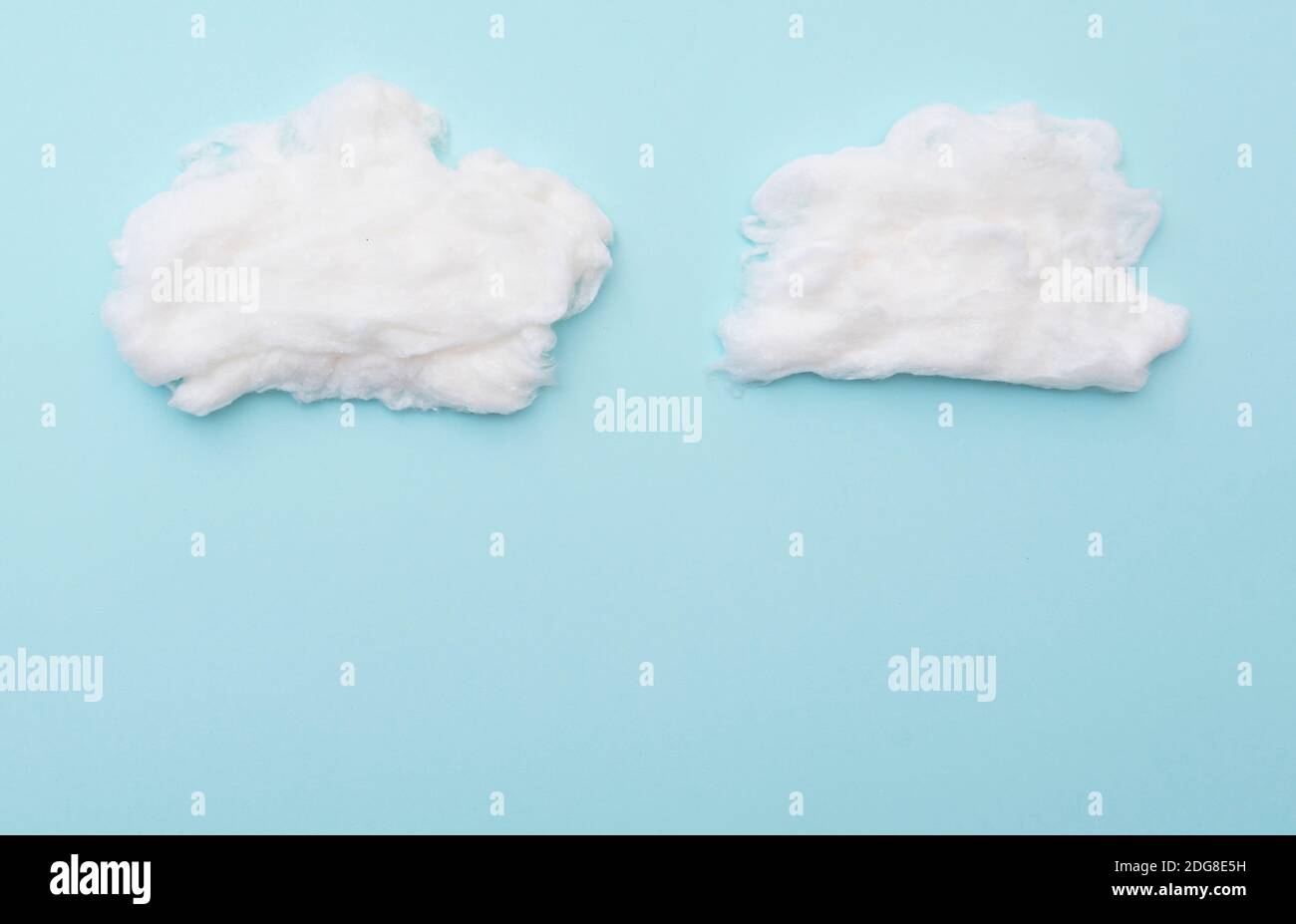Cumulus nuvole di lana di cotone su superficie blu, layout per idee, spazio per il testo Foto Stock