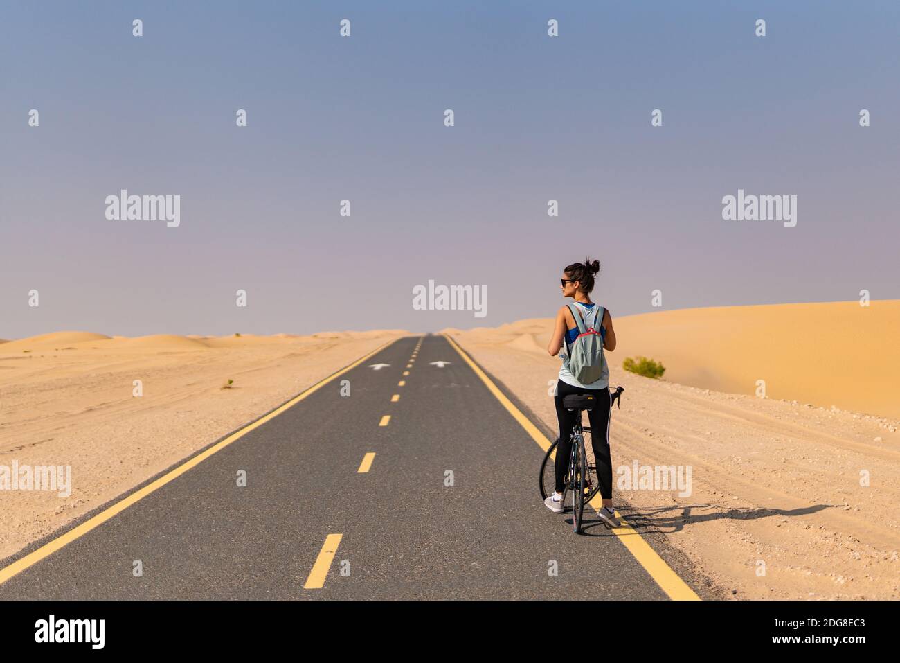 Lady smette di andare in bicicletta per afferrare un'acqua Foto Stock