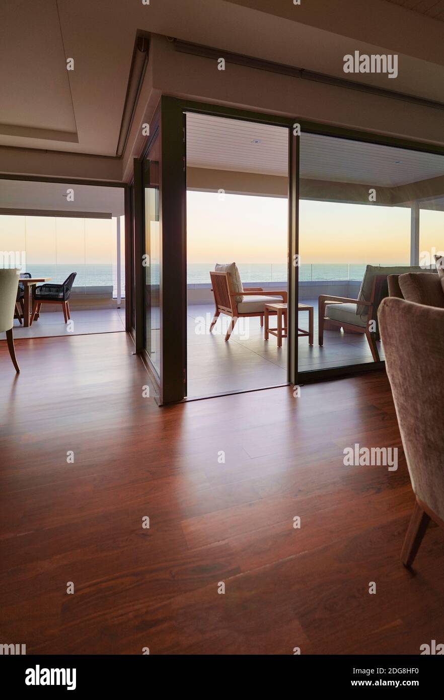 Pavimenti in legno duro in casa vetrina interni con vista mare tramonto Foto Stock