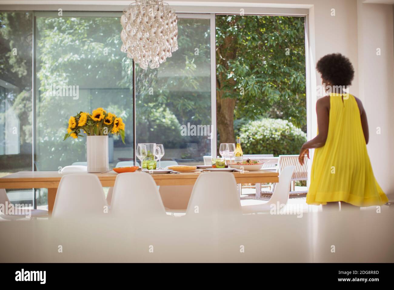 Donna in abito giallo tavolo da pranzo per pranzo Foto Stock