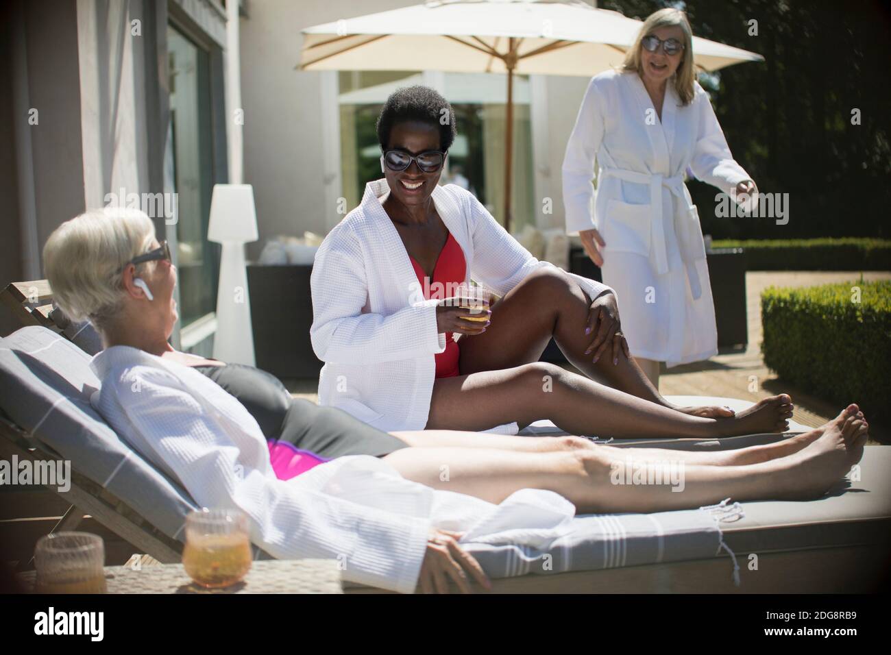 Felici le donne anziane che si rilassano in abiti spa al sole patio dell'hotel Foto Stock