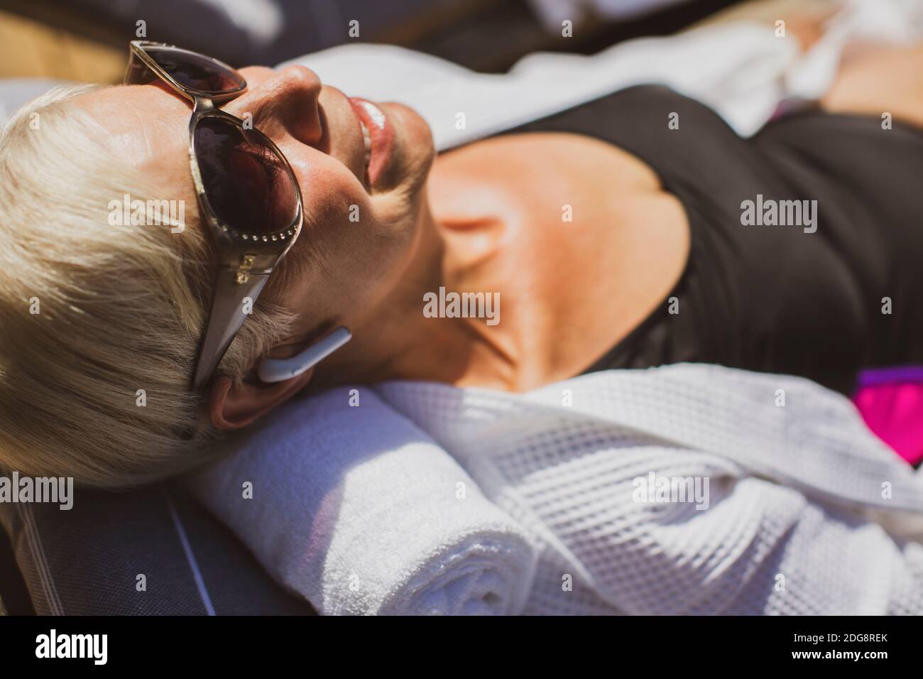 Primo piano donna anziana felice in occhiali da sole prendere il sole Foto Stock