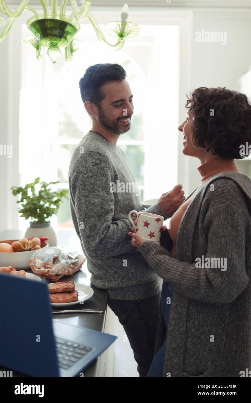 Felice coppia che parla e beve caffè in cucina mattina Foto Stock