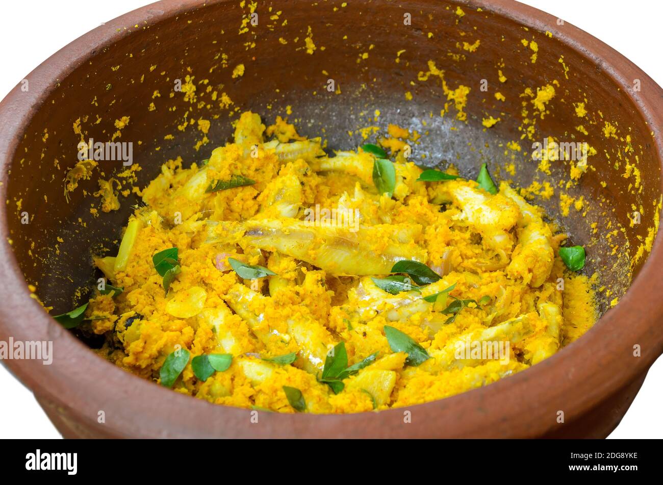 Primo piano di curry di pesce secco di cocco in stile Kerala che viene cucinato in una pentola di terra. Isolato. Foto Stock