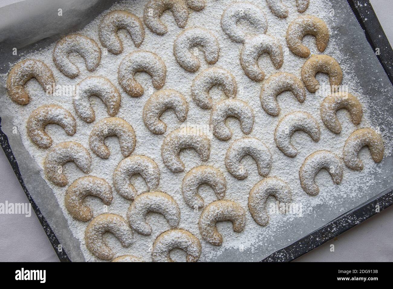 Una teglia da forno con Vanillekipferl fresco dal forno. I Vanillekipferl sono piccoli biscotti a forma di mezzaluna fatti con frutta a guscio e vaniglia. Foto Stock