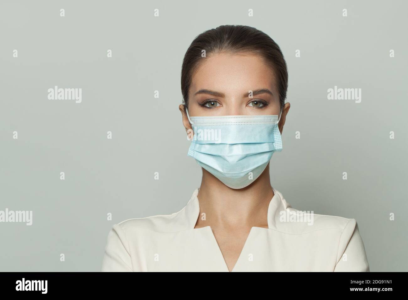 Infermiere o medico donna in maschera medica protettiva sul viso bianco Foto Stock