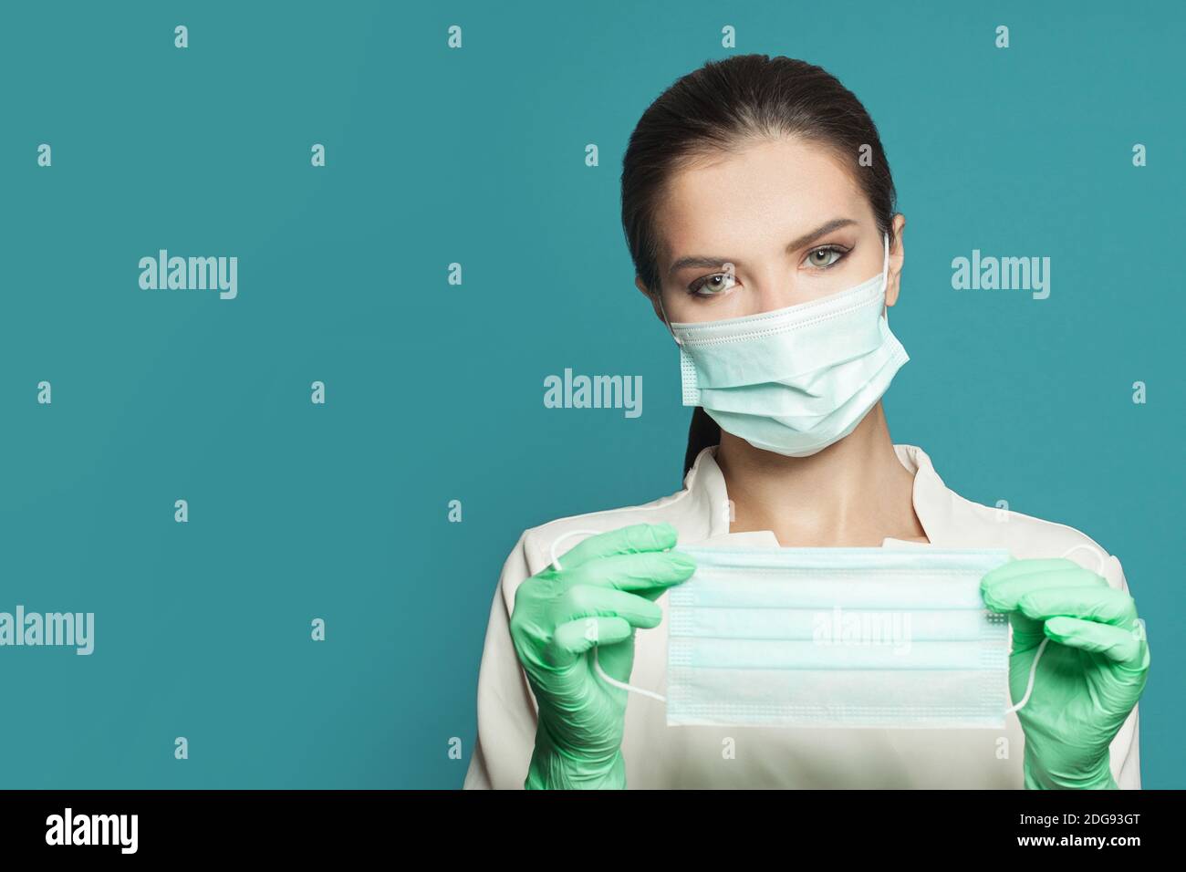 Ritratto del medico con maschera medica protettiva su sfondo blu. Concetto di medicina Foto Stock