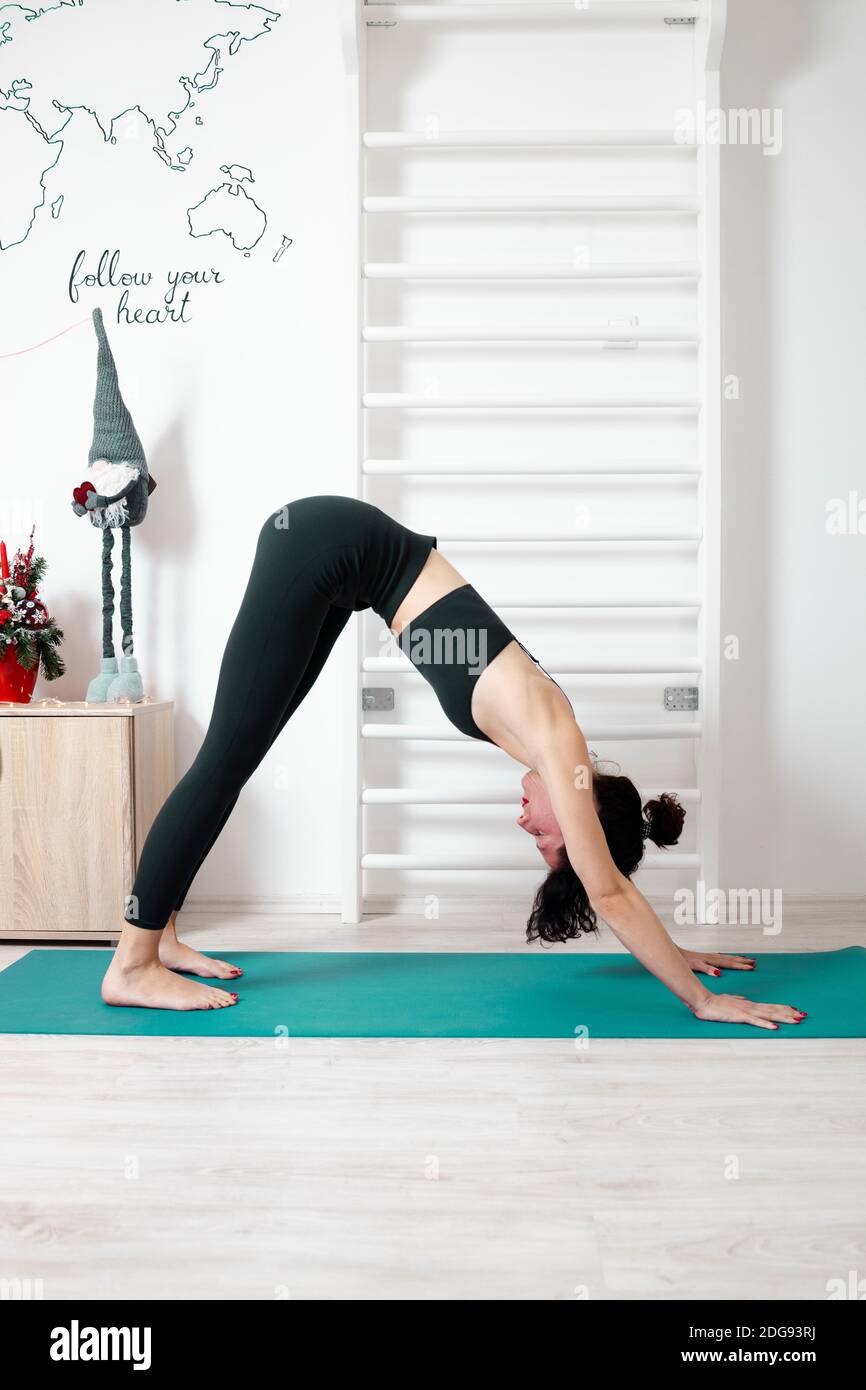 Giovane donna che esercita yoga nel suo proprio appartamento e godendosi il suo giorno Foto Stock