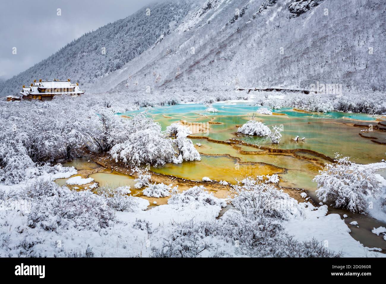Vista sul lago dai colori ghiacciati e sul tempio tibetano Foto Stock