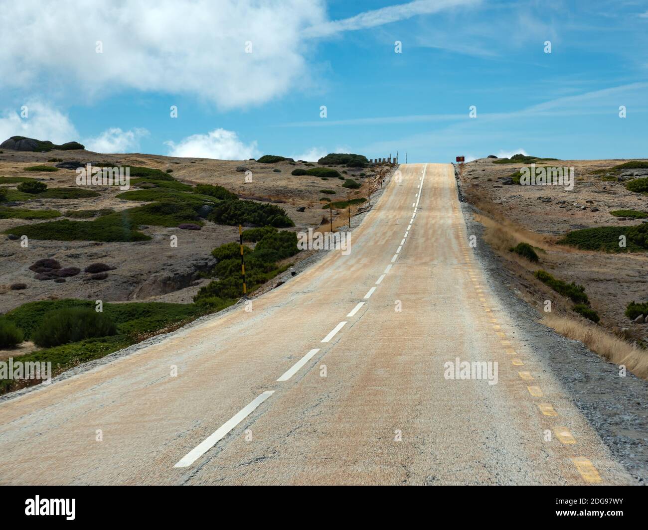 Strada a due vie in salita con fine nel cielo blu Foto Stock